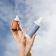 Mãos segurando o sérum de bakuchiol e o sabonete facial Soft Clean Sousènsi