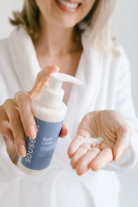 Mulher aplicando o sabonete facial Soft Clean Sousènsi na palma da mão