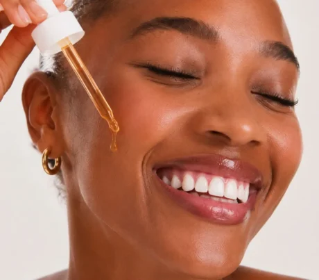 Mulher sorrindo ao aplicar o sérum de bakuchiol Sousènsi